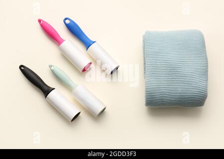 Lint rollers and clothes on color background Stock Photo