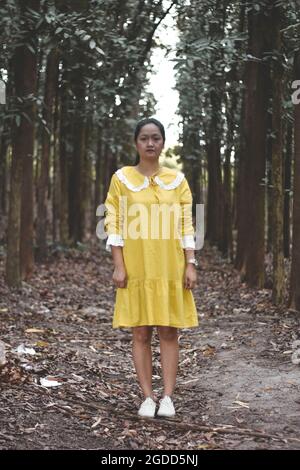 Woman standing in the middle of the forest Stock Photo