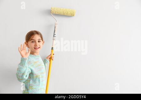 Little girl painting wall in room Stock Photo