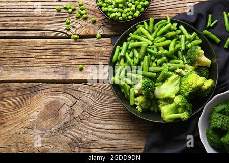 Composition with frozen green vegetables on wooden background Stock Photo