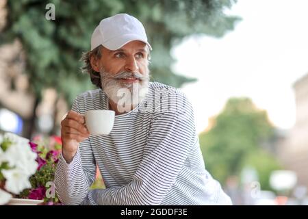 Handsome mature man drinking coffee in cafe Stock Photo