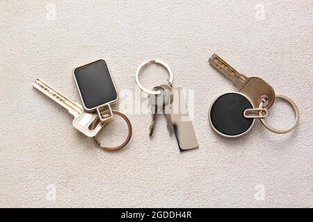 Keys with stylish keychains on light background Stock Photo