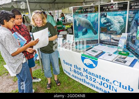 Miami Florida,Little Havana,Miami Riverday Jose Marti Park festival,save manatee club information endangered species Hispanic boys teens teenagers,stu Stock Photo