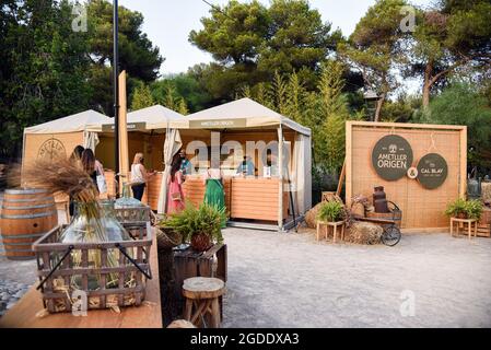 Sitges, Spain. 13th Aug, 2021. A view of the Village Area of the Jardins de Terramar Festival in Sitges. Every year the city of Sitges (Barcelona, Spain) hosts the Jardins de Terramar Festival where international singers perform live. Hours before each concert, visitors can taste Mediterranean cuisine, wines and cavas (Champagne from the region of Catalonia) at the Gastro Village in a relaxed atmosphere in its Chill Out area. Musical performances are held to entertain the public. Credit: SOPA Images Limited/Alamy Live News Stock Photo