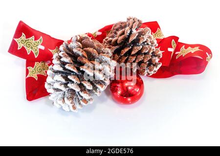 Christmas pine cones with red ornament and red bow isolated on white background. Stock Photo