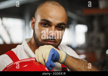 Portrait of young tired african american workman in cable production plant Stock Photo