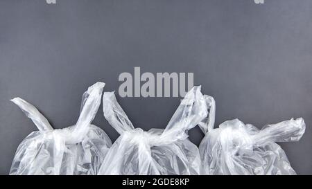 Three plastic bags on dark background, environmental pollution concept. Stock Photo