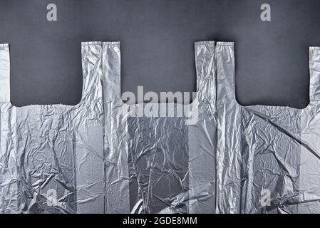 Three plastic bags on dark background, environmental pollution concept. Stock Photo