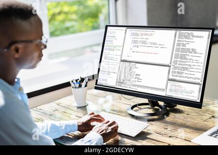 African American Coder Using Computer At Desk. Web Developer Stock Photo