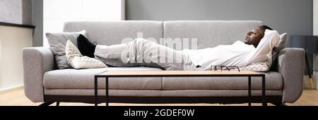 Happy Man Relaxing On Sofa Or Couch Stock Photo