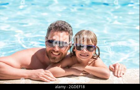 happy family of daddy and little boy having fun in summer swimming pool, family Stock Photo