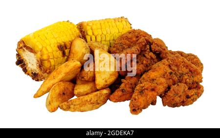 Fried spicy breadcrumb covered chicken fillets and potato wedges with corn on the cob meal isolated on a white background Stock Photo
