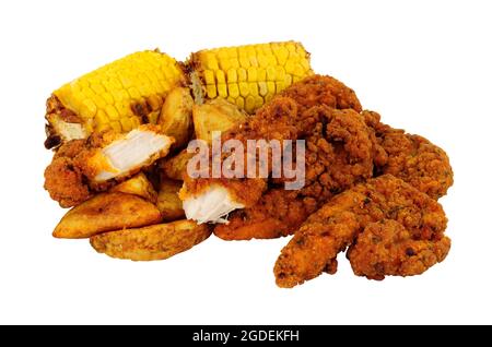 Fried spicy breadcrumb covered chicken fillets and potato wedges with corn on the cob meal isolated on a white background Stock Photo