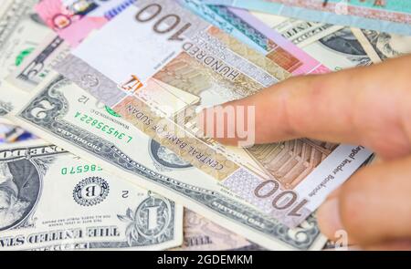 Male hand hold 100 Sudanese pounds banknote, the currency of Sudan. Close up Paper Money of the arabic country with high inflation. Old man hands show Stock Photo