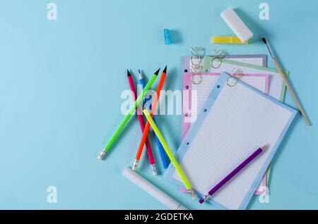 Layout of advertising of school goods. Stationery on a blue background. Various pencils and notebooks for writing Stock Photo