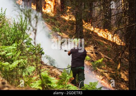 San Luca, Italy. 10th Aug, 2021. A member of Calabria Verde tries to douse fire at Aspromonte National Park.Wildfires have been ravaging forests of Aspromonte National Park in Calabria for more than a week. For the protection of the area and trees, the park was recently included in the UNESCO's natural heritage list, a mobile unit of the Civil Protection from Lombardy had been deployed in San Luca's area, from 10 August, to help Calabria Verde (regional environmental agency) and other forces to fight fires. Credit: SOPA Images Limited/Alamy Live News Stock Photo