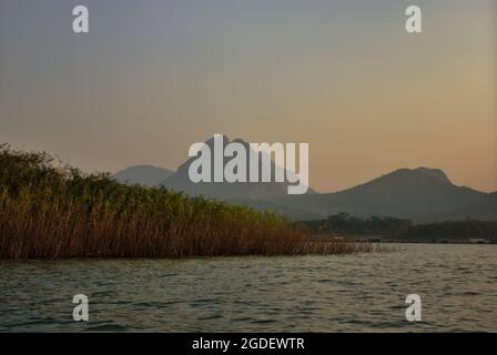 Jatiluhur dam and lake vegetation in a background of the towering Mount Parang in Purwakarta, West Java, Indonesia. Stock Photo