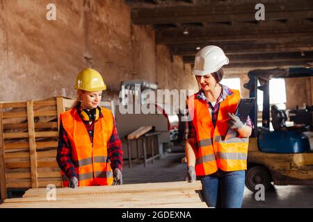 The young women in uniform working in a factory Stock Photo