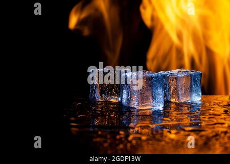 three ice cubes and flames on a black background, place under the text Stock Photo