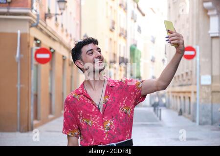 Young caucasian man with long false nails taking a selfie with his phone. Stock Photo