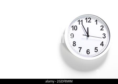 It is five to twelve, the clock is ticking. White Watch shows the time 5 before 12. Close up to a wall clock, with five minutes to twelve o'clock. Tim Stock Photo