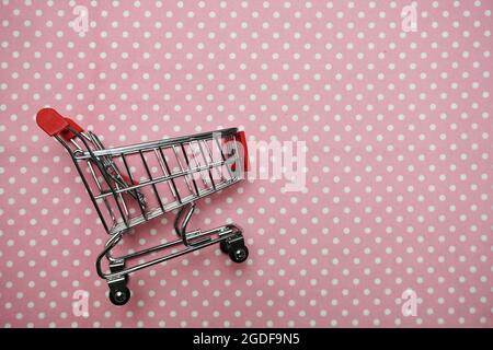 Mini trolley shopping cart on Pink polka dot background Stock Photo