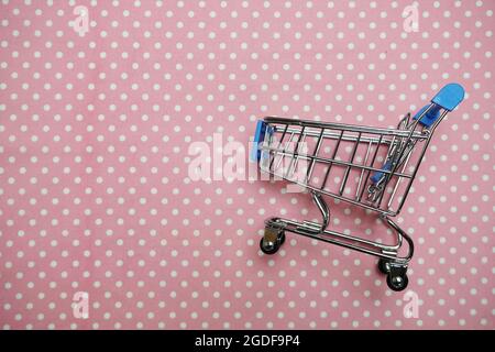 Mini trolley shopping cart on Pink polka dot background Stock Photo