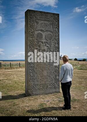 Lady looks at the symbols on the reconstructed Hilton of Cadboll Pictish standing stone Stock Photo