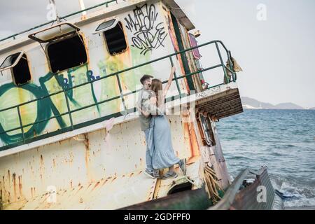 Picture of happy young couple in the old port with graffiti. Kissing, cuddling, having fun. High quality photo Stock Photo