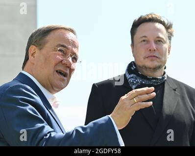 Brandenburg, Germany. 13 August 2021:: Armin Laschet (l), CDU Federal Chairman and Minister President of North Rhine-Westphalia, and Elon Musk, Tesla CEO, speak to journalists in front of what will later be the main entrance to the Tesla Gigafactory. In Grünheide near Berlin, the first vehicles are to roll off the production line from the end of 2021. The US company plans to build around 500,000 units of the compact Model 3 and Model Y series here each year. Credit: dpa picture alliance/Alamy Live News Stock Photo