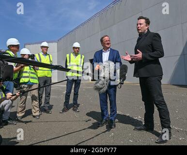 Brandenburg, Germany. 13 August 2021:: Elon Musk (r), Tesla CEO, and Armin Laschet, CDU Federal Chairman and Minister President of North Rhine-Westphalia, speak to journalists in front of what will later be the main entrance to the Tesla Gigafactory. The first vehicles are to roll off the production line in Grünheide near Berlin from the end of 2021. The US company plans to build around 500,000 units of the compact Model 3 and Model Y series here each year. Credit: dpa picture alliance/Alamy Live News Stock Photo