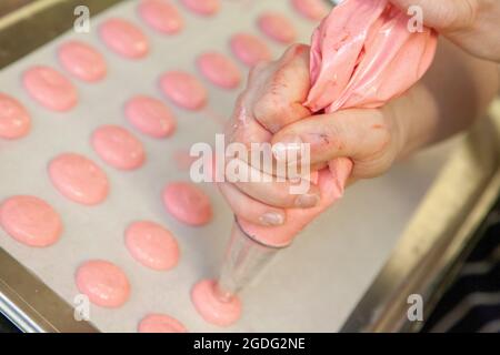 Pink macarons --- Macaronor French macaroon is a sweet meringue-based confection made with egg white, icing sugar, granulated sugar, almond meal, and Stock Photo