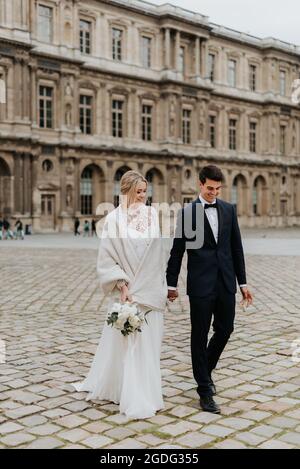 Bride and bridegroom on cobblestone street, Paris, France Stock Photo