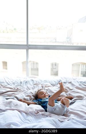 Toddler playing on bed Stock Photo