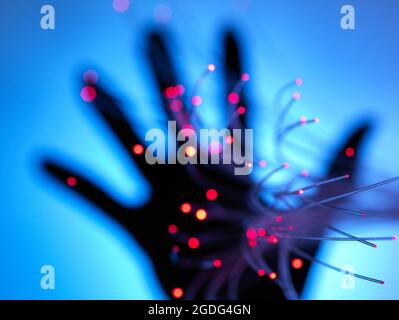Digital age: artificial intelligence fibre optics carrying data passing through hand Stock Photo