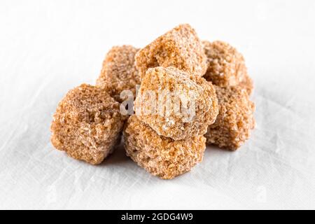 Isolated handful of brown cane sugar cubes Stock Photo