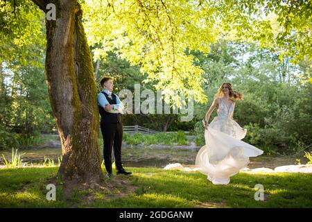 Man watches while beautiful woman in dress spins. Stock Photo