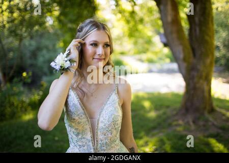 Attractive young woman tucks her hair back. Stock Photo