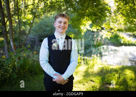Handsome young man standing with arms crossed in nature. Stock Photo