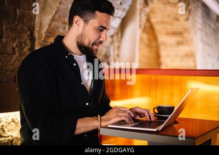 Happy businessman using laptop computer at cafe Stock Photo