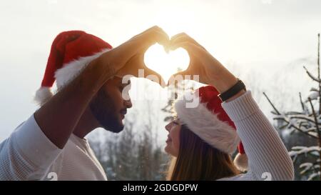 the young couple shows that it is brighter than the sky in the sign of the heart. High-quality photo Stock Photo