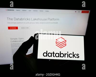 Person holding smartphone with logo of US enterprise software company Databricks Inc. on screen in front of website. Focus on phone display. Stock Photo