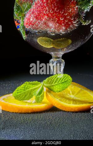Piece of cake with chocolate and delicate lemon cream and strawberrys. A glass of red wine with strawberries and oranges shared with a loved one Stock Photo
