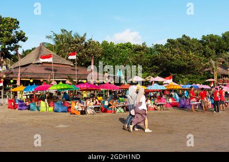 Kuta, Indonesia - September 14, 2018: Tourists and locals strolling and enjoying sunset at Seminyak beach in Bali. It is one of tourists attraction in Stock Photo