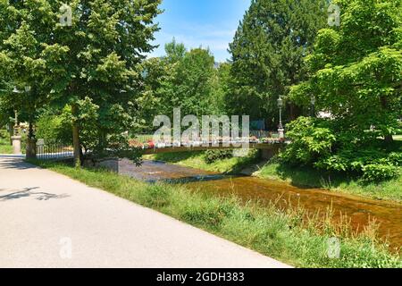 Bridge over river Oos with flowers in park called 'Lichtentaler Alle' in health resort Baden-Baden in Germany Stock Photo