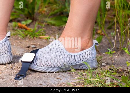 https://l450v.alamy.com/450v/2gdh537/the-close-up-photo-of-the-legs-of-a-fitness-woman-in-the-summer-moccasins-with-digital-watch-fell-on-her-one-foot-while-she-was-practicing-sport-2gdh537.jpg