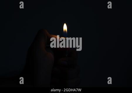Cigarette Lighter in the hand on a dark background Stock Photo