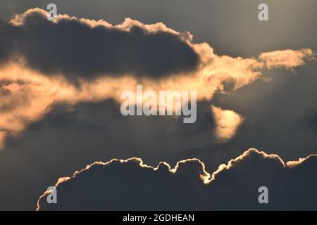 Evening sun behind dark clouds Stock Photo