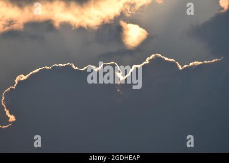 Evening sun behind dark clouds Stock Photo