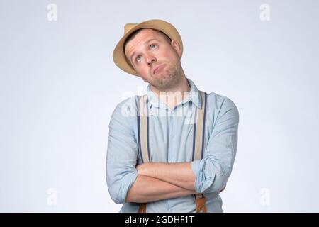 Young thoughtful man looking up generating idea, making plans for future. Stock Photo